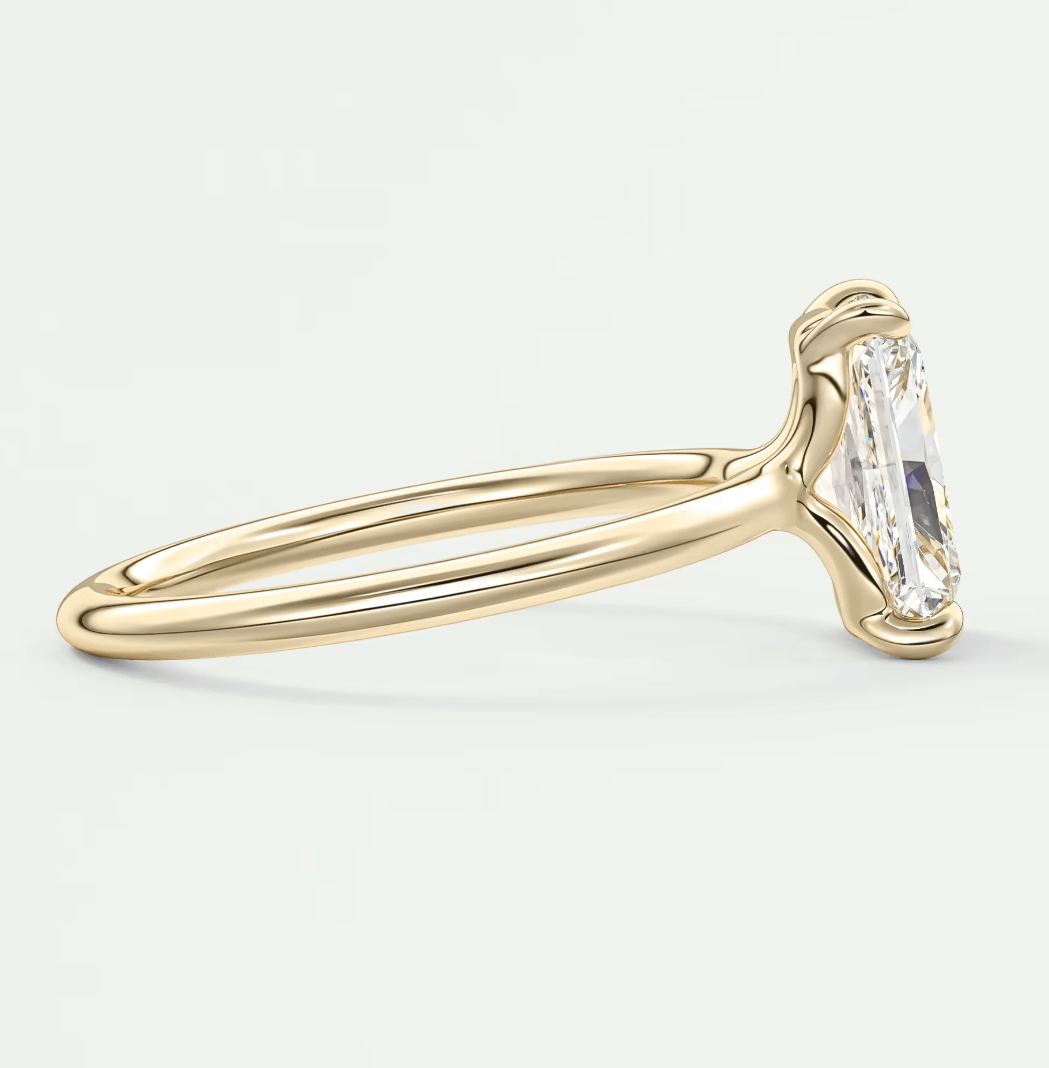 18k yellow gold emerald-cut diamond engagement ring with a twisted band design.