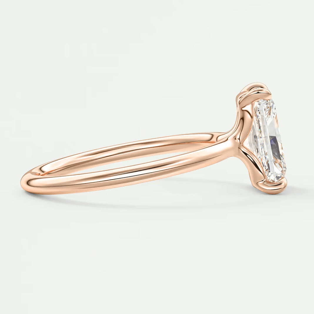 Rose gold emerald cut diamond engagement ring with twisted band design.