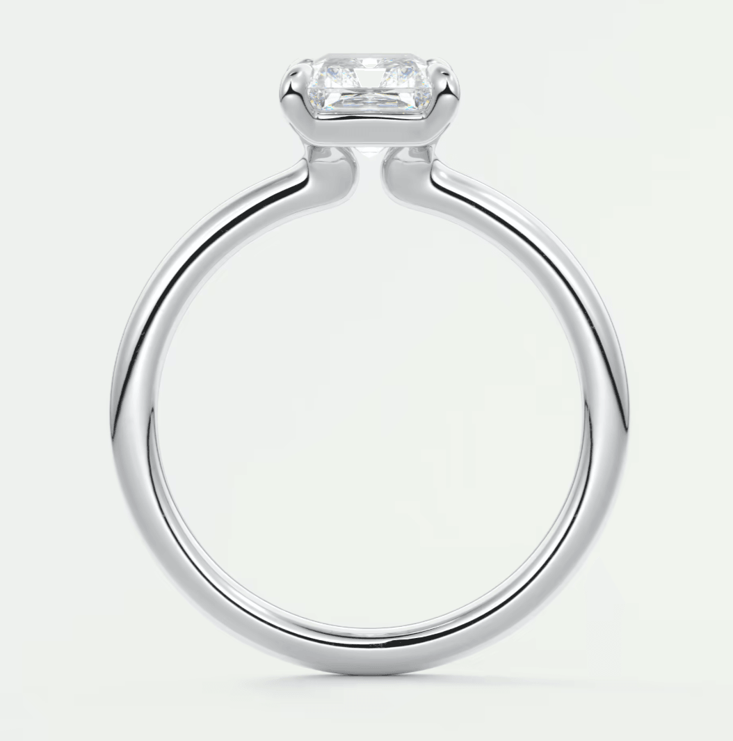 White gold emerald cut diamond engagement ring with a cushion-shaped stone.