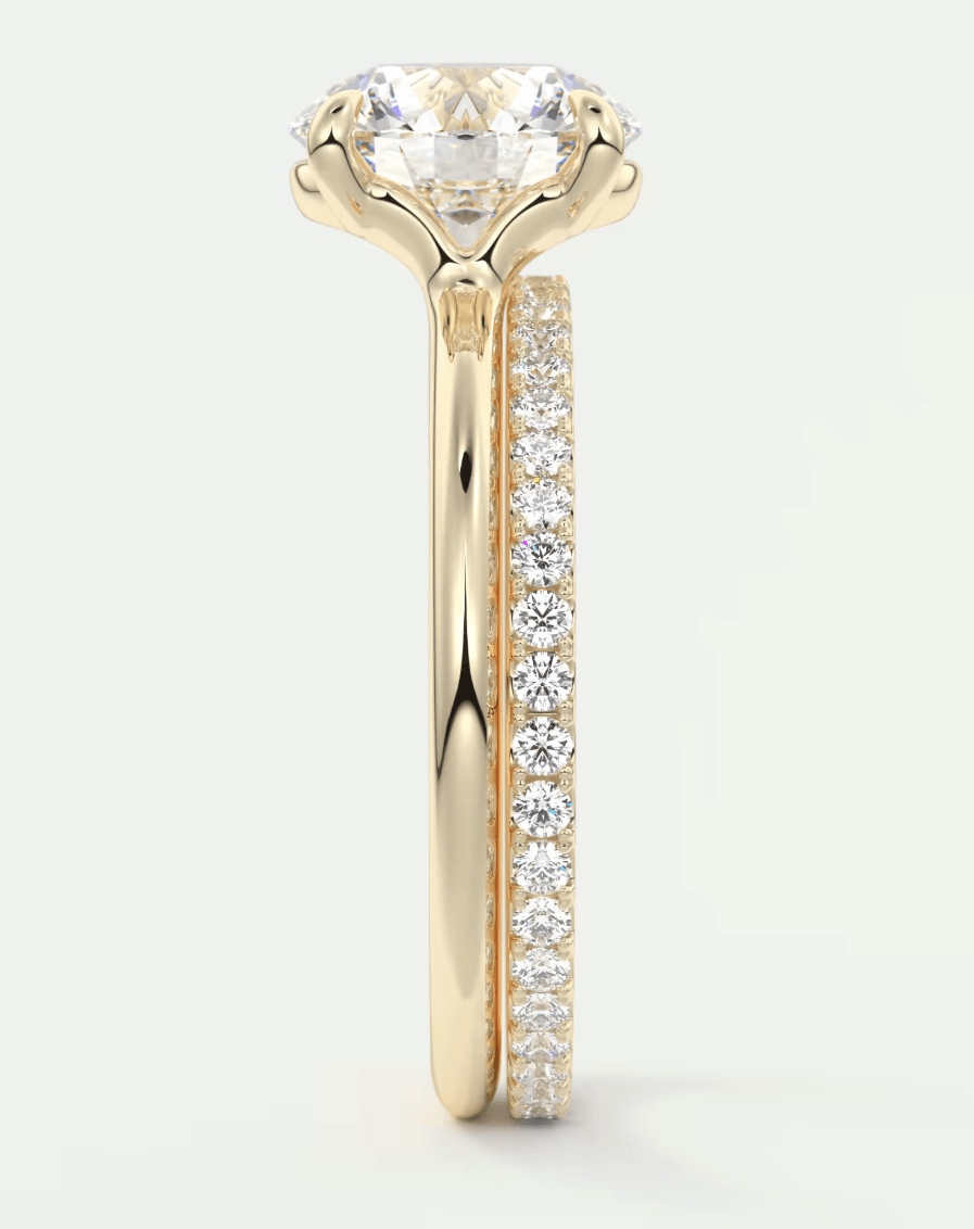 18k yellow gold engagement ring with a round diamond center stone and pavé set diamonds on the band.