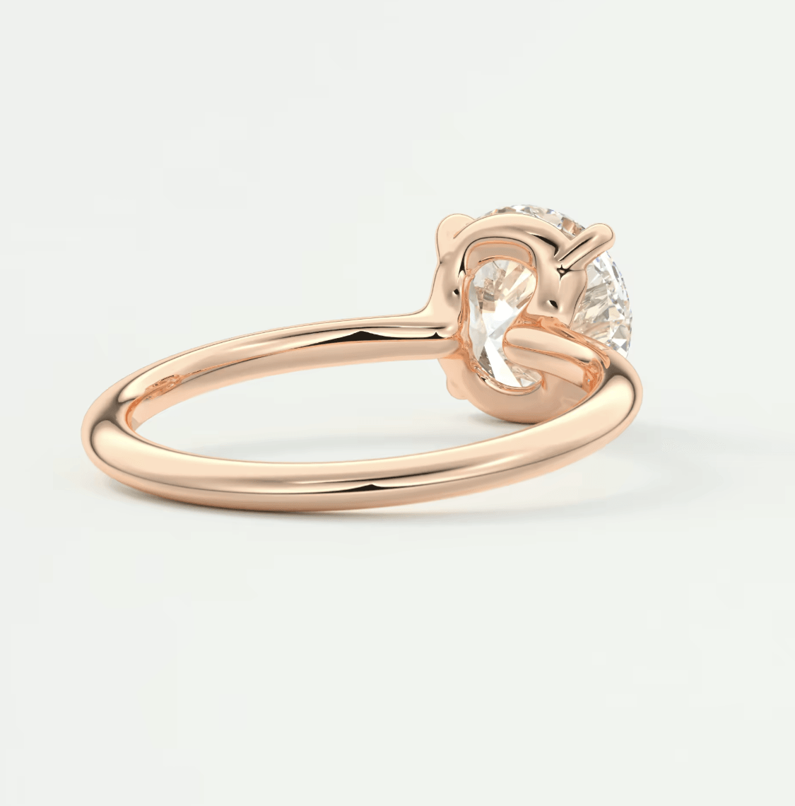 18-karat rose gold engagement ring with a round diamond.