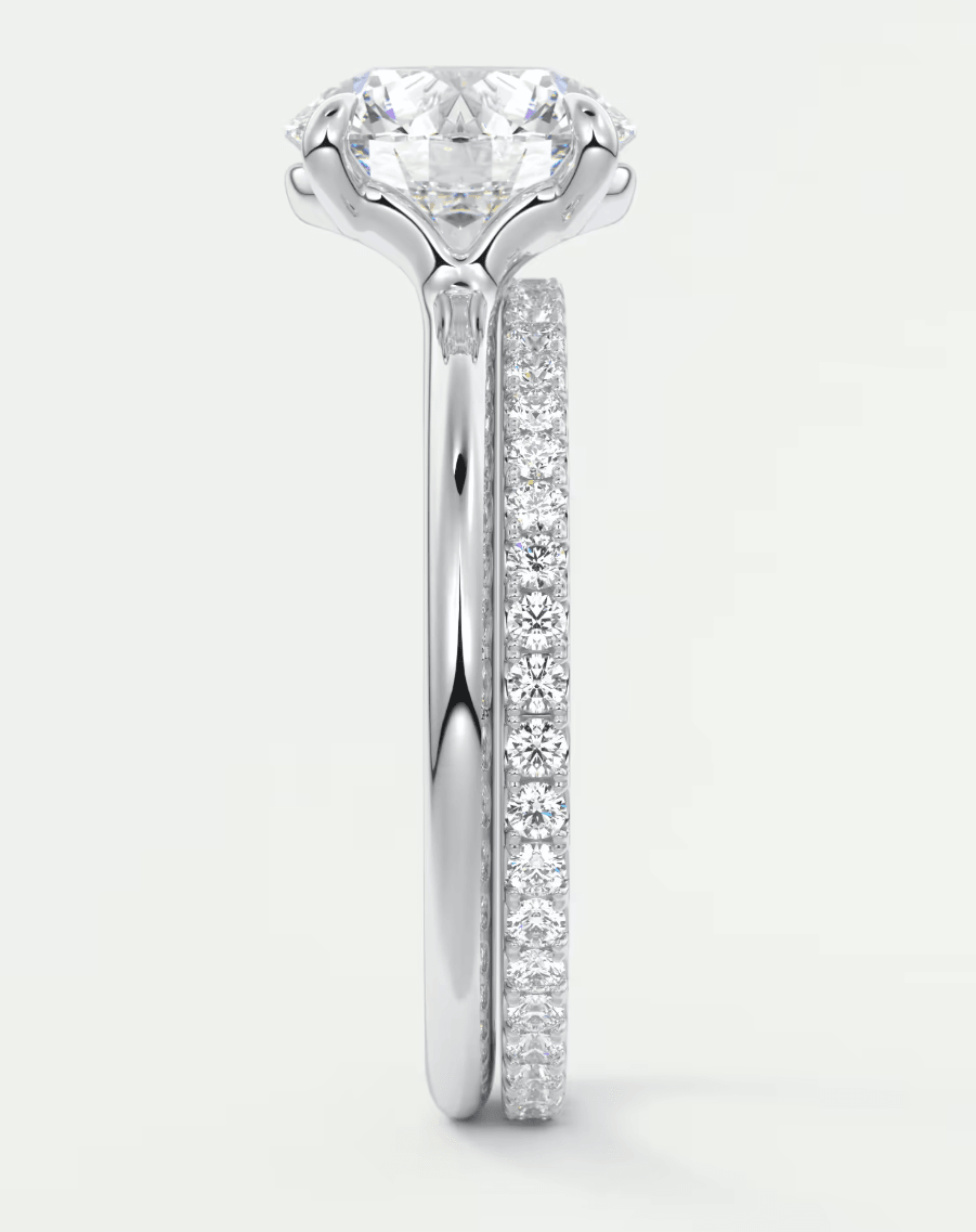 18-karat white gold diamond engagement ring with a round brilliant cut center stone and pavé set diamonds on the band.