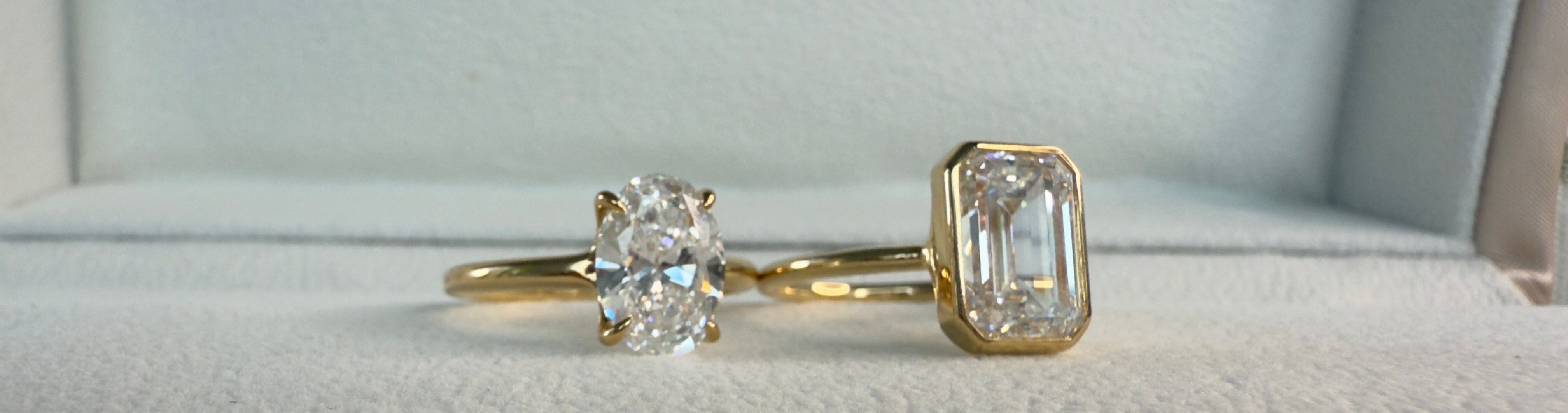 Two gold rings with diamond stones on a 'Diamond Lab' branded box.