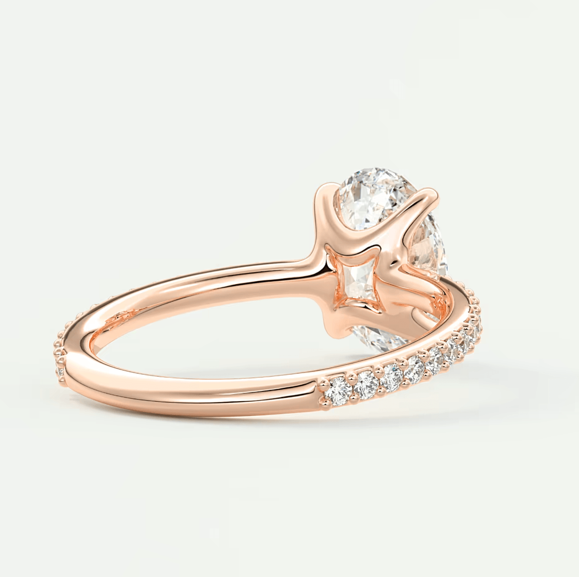 Rose gold diamond engagement ring with a solitaire design and pave set diamonds on the band.