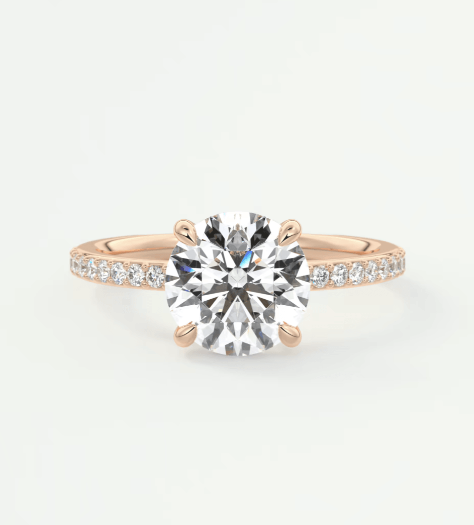 18k rose gold diamond engagement ring with a round brilliant cut center stone and pave set diamonds on the band.