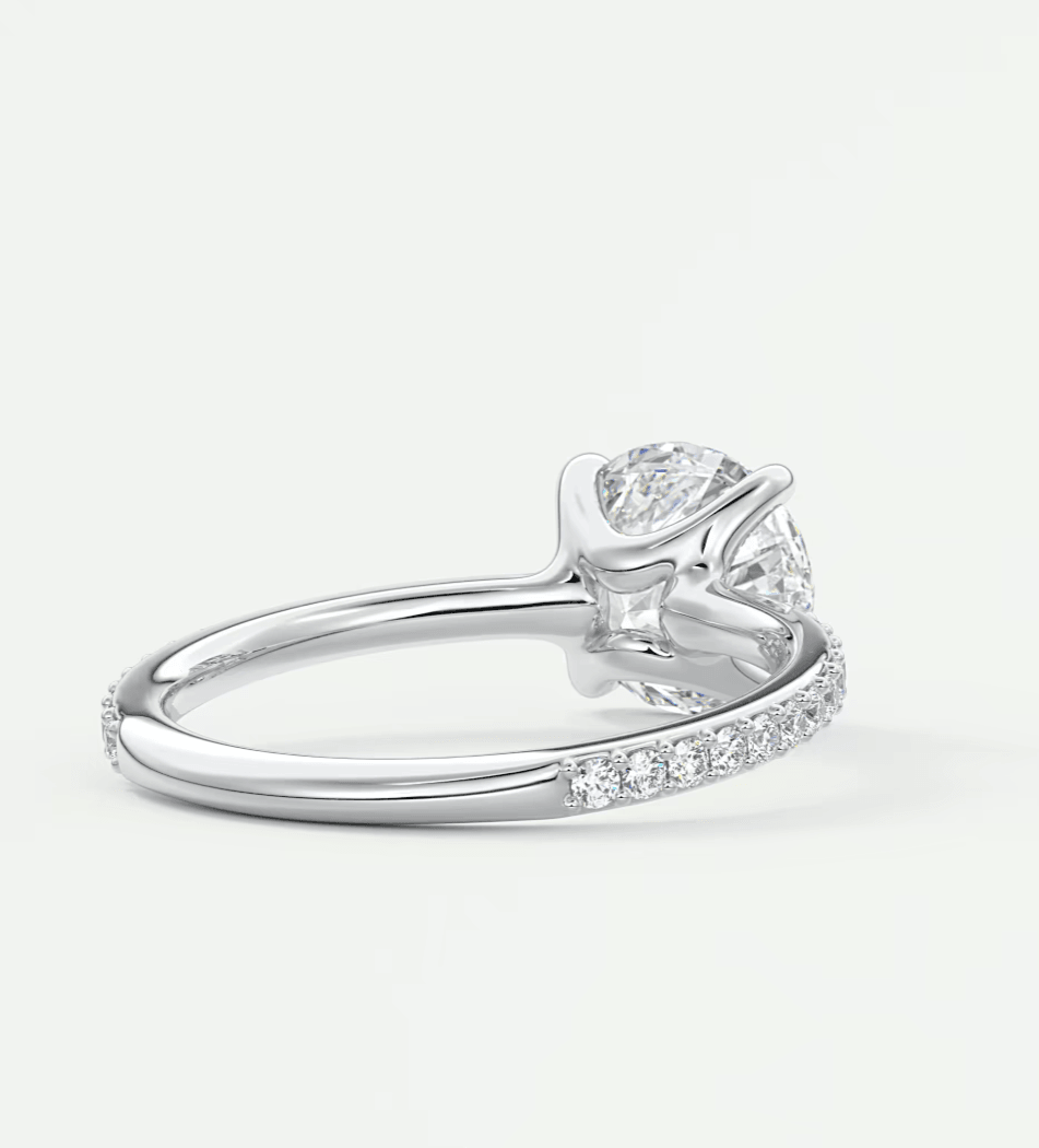 18-karat white gold diamond engagement ring with a round-cut center stone and pave-set diamonds on the band.