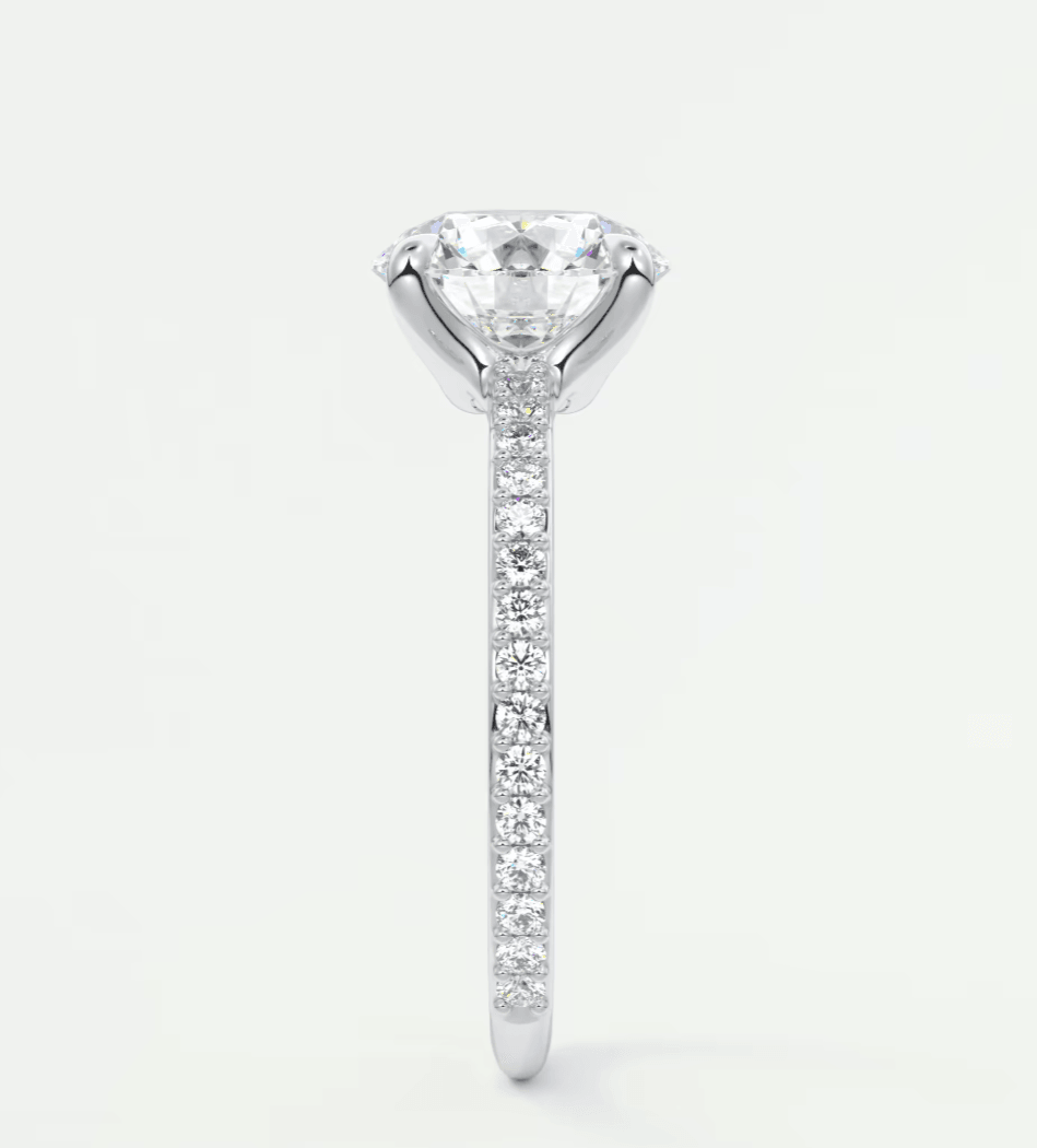 18-karat white gold diamond engagement ring with a round brilliant cut center stone and pave-set diamonds on the band.