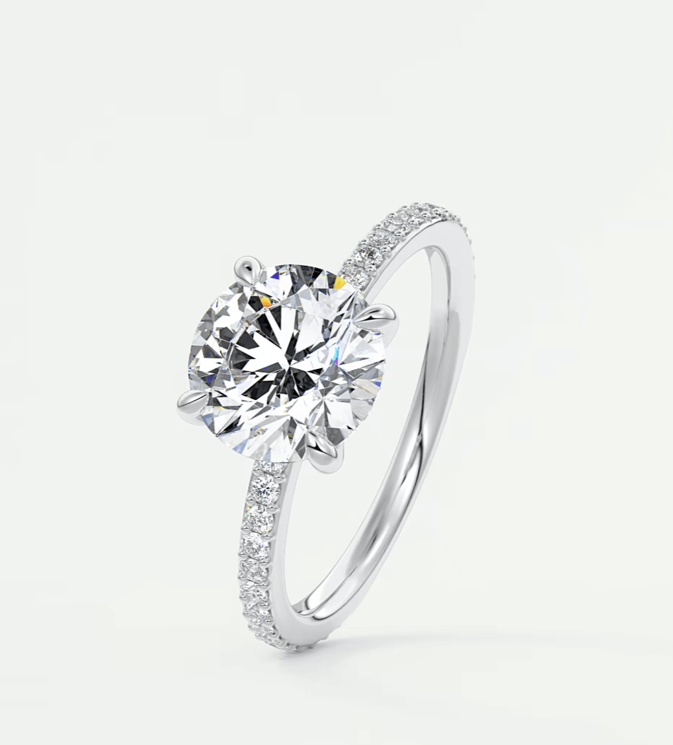 18-karat white gold engagement ring with a round diamond center stone and pave-set diamonds on the band.