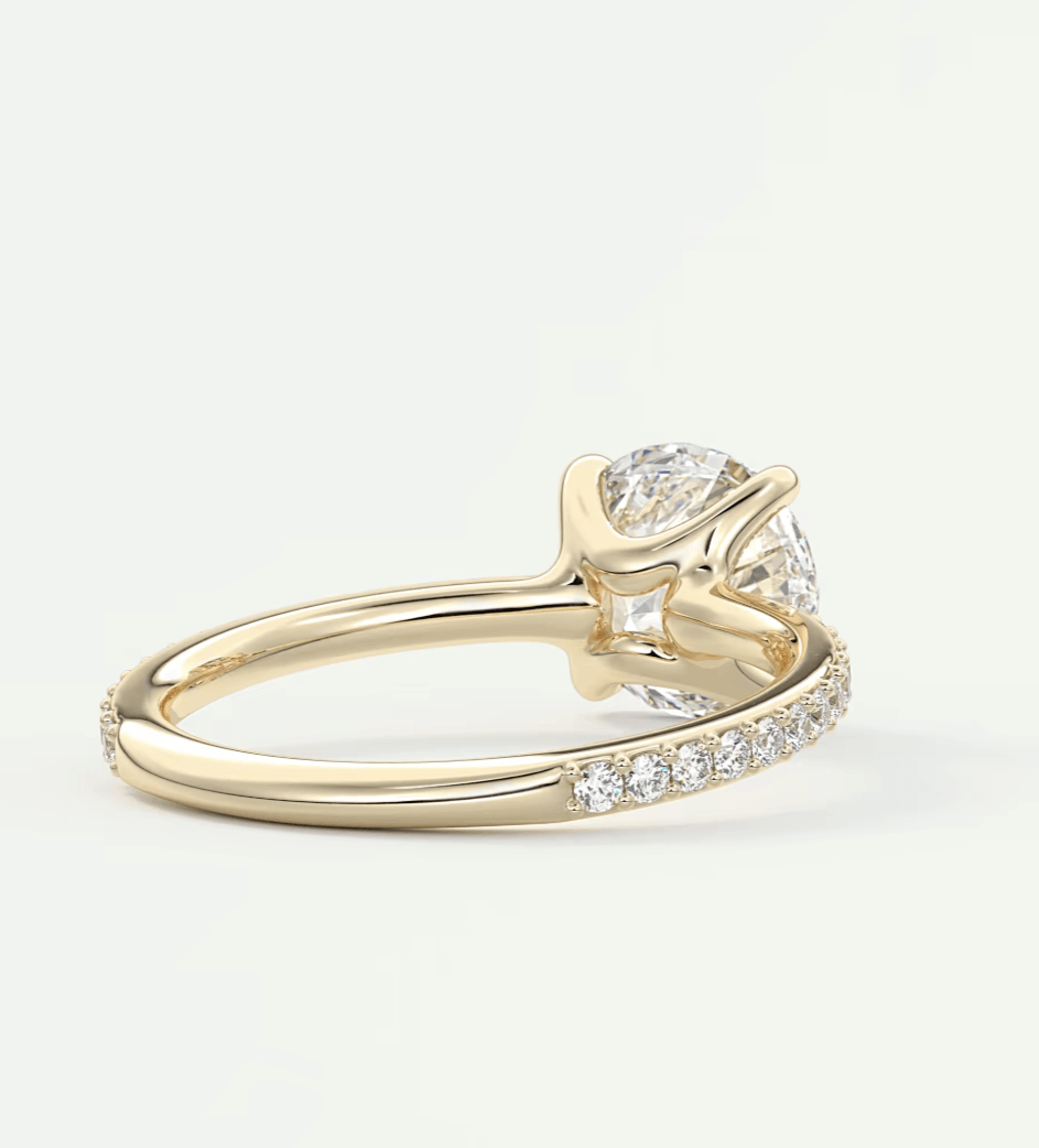 18-karat yellow gold engagement ring with a pear-shaped diamond and pave-set diamonds on the band.