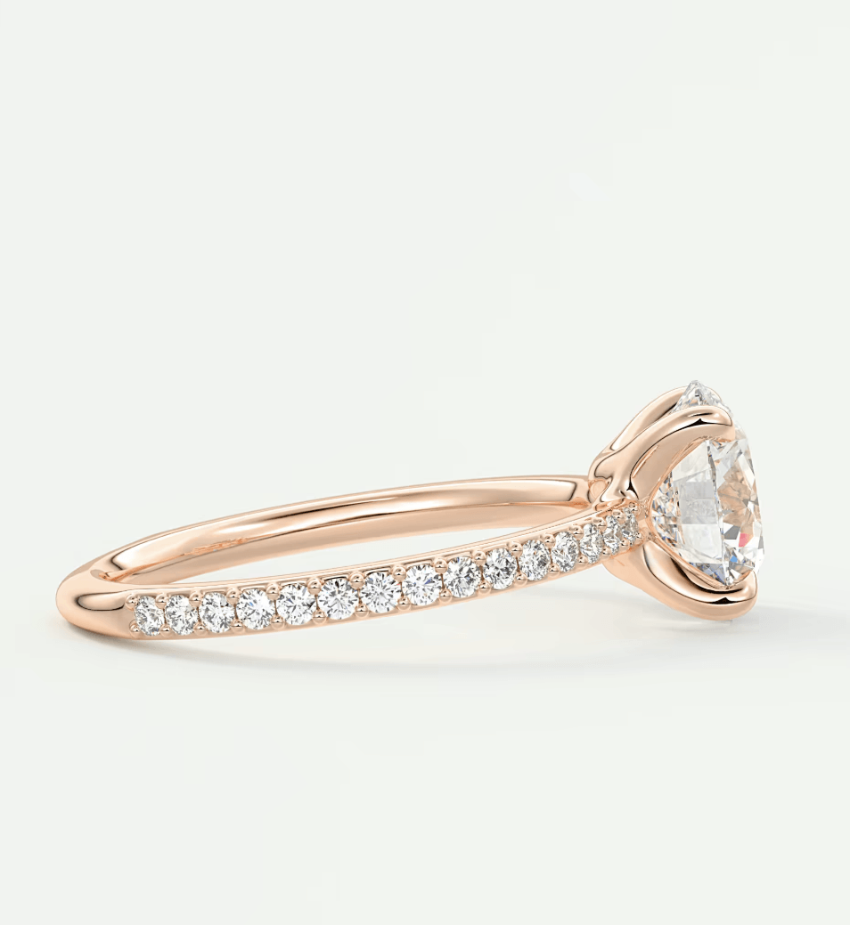 18k rose gold diamond engagement ring with a marquise-cut center stone and pave-set diamonds on the band.