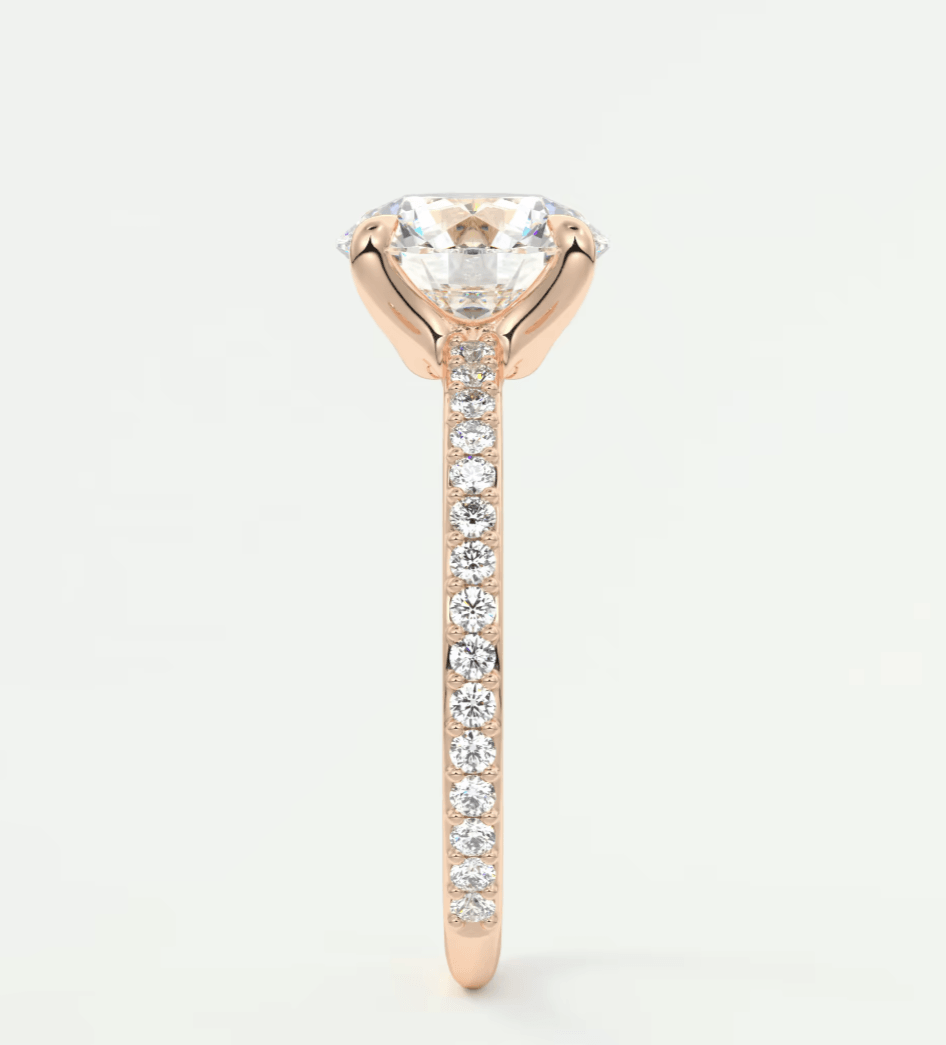18-karat rose gold engagement ring with a round diamond center and pave-set diamonds on the band.