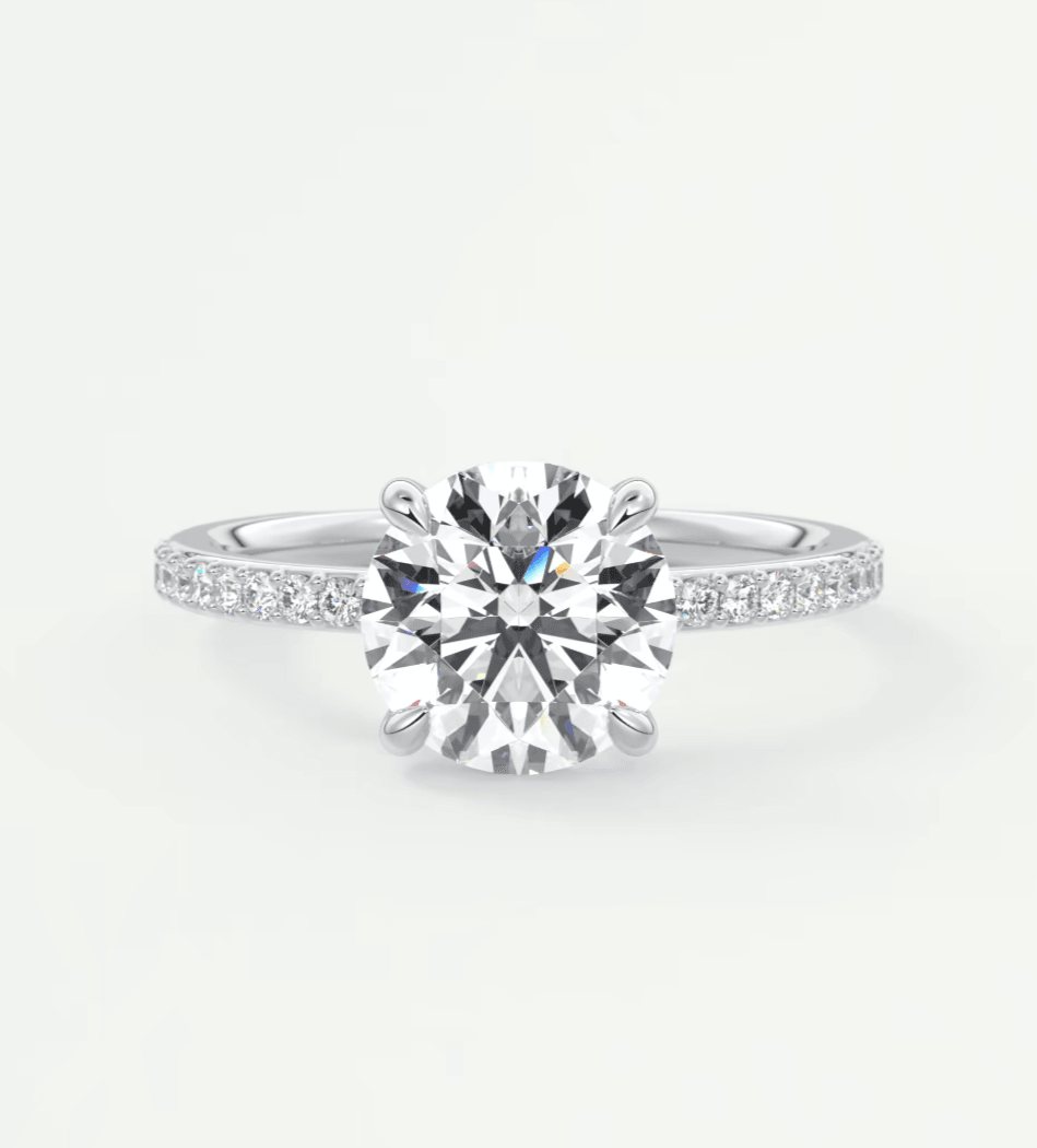 18-karat white gold diamond engagement ring with a round brilliant cut center stone and pave set diamonds on the band.