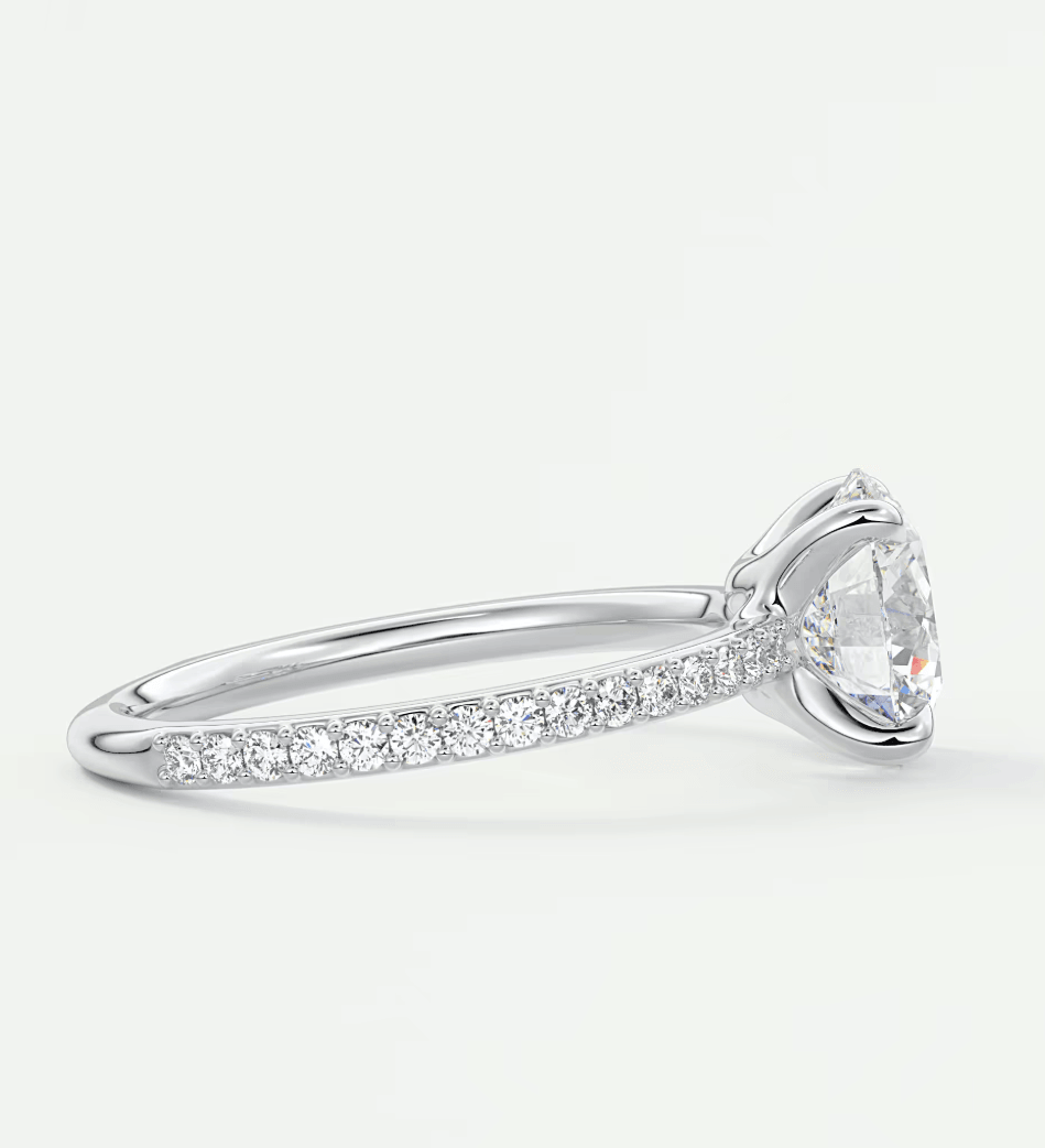 18k white gold diamond engagement ring with a round-cut center stone and pave-set diamonds on the band.