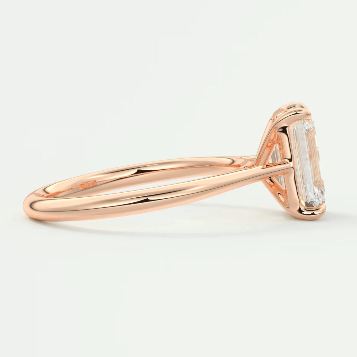 18-karat rose gold engagement ring with an emerald-cut diamond.