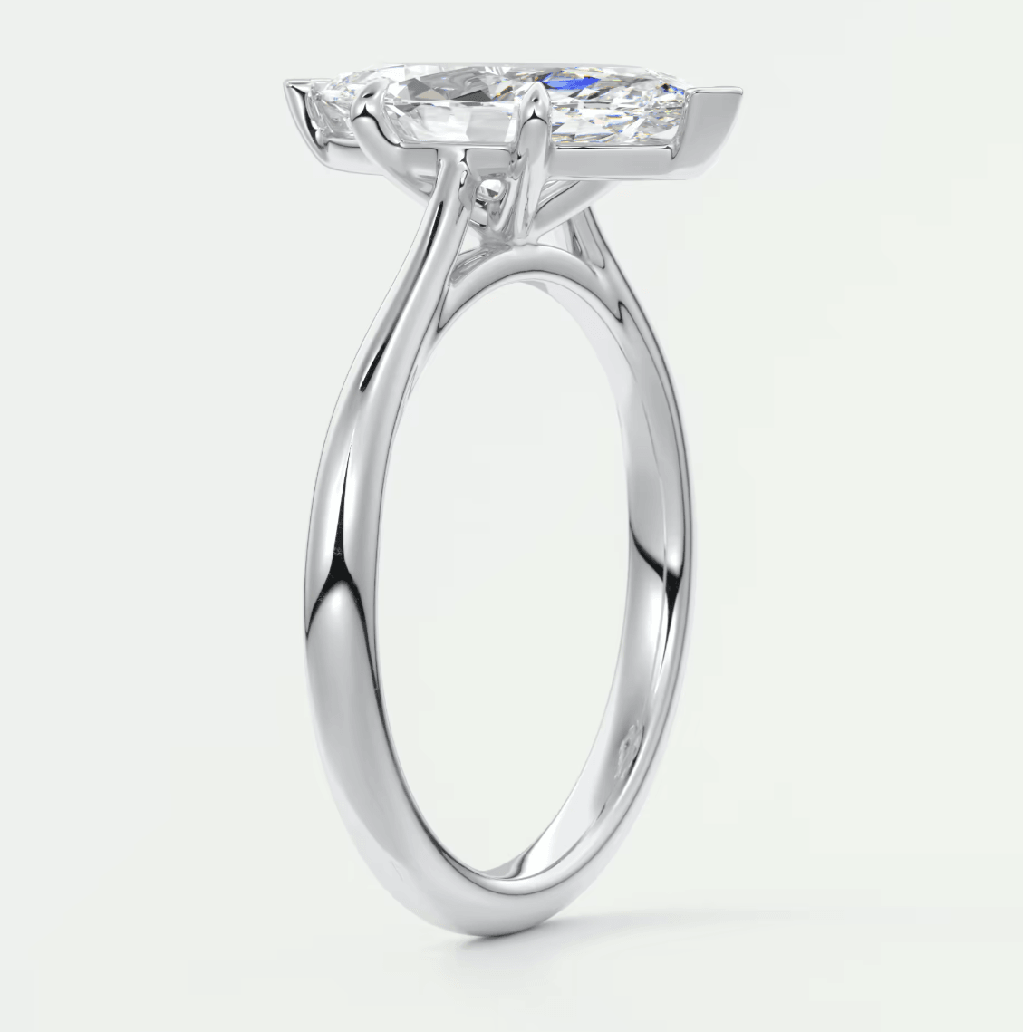 18-karat white gold engagement ring with a marquise-cut diamond and small round diamonds on the band.