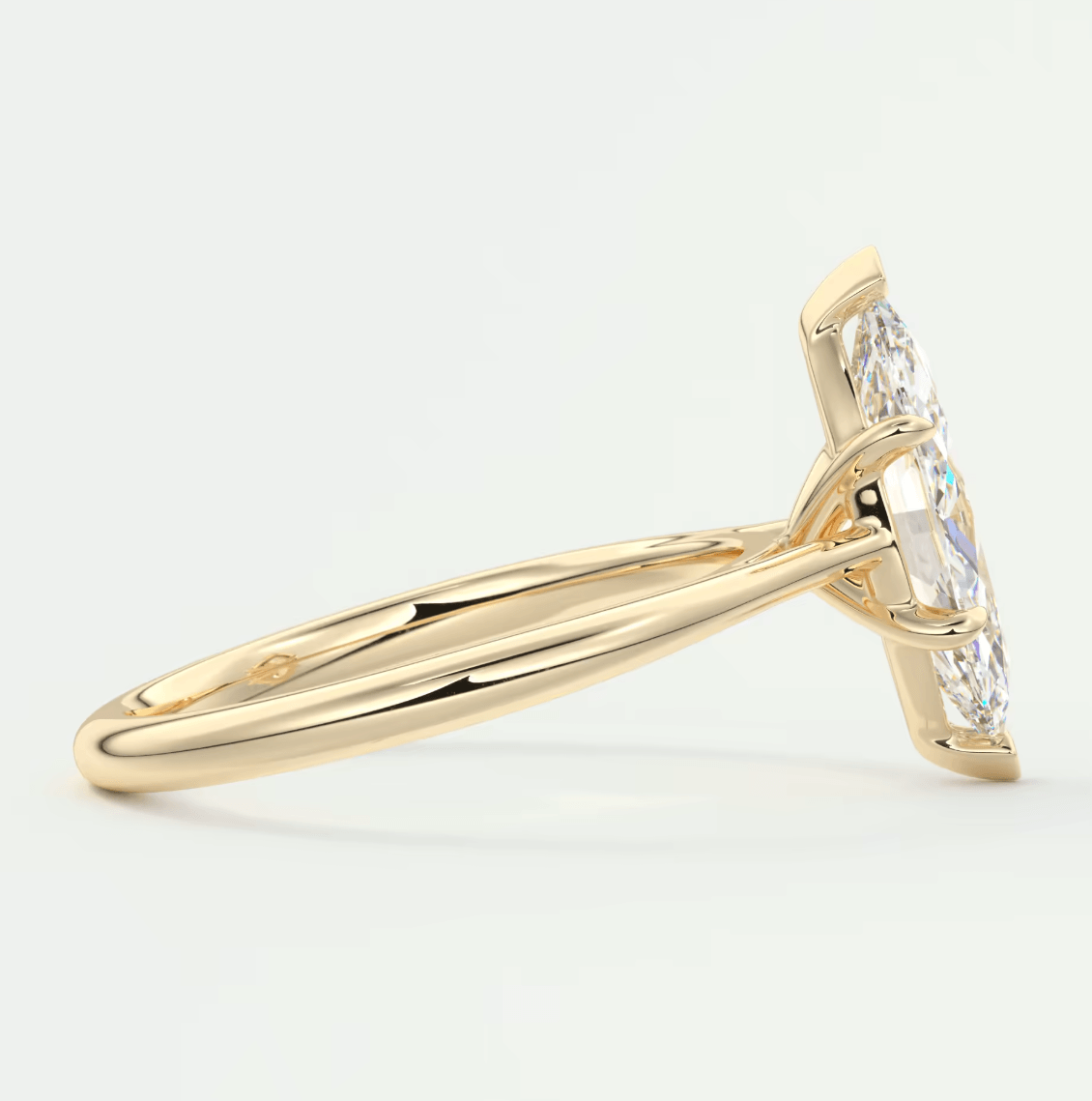 18k yellow gold diamond engagement ring with a marquise-cut center stone and baguette side stones.