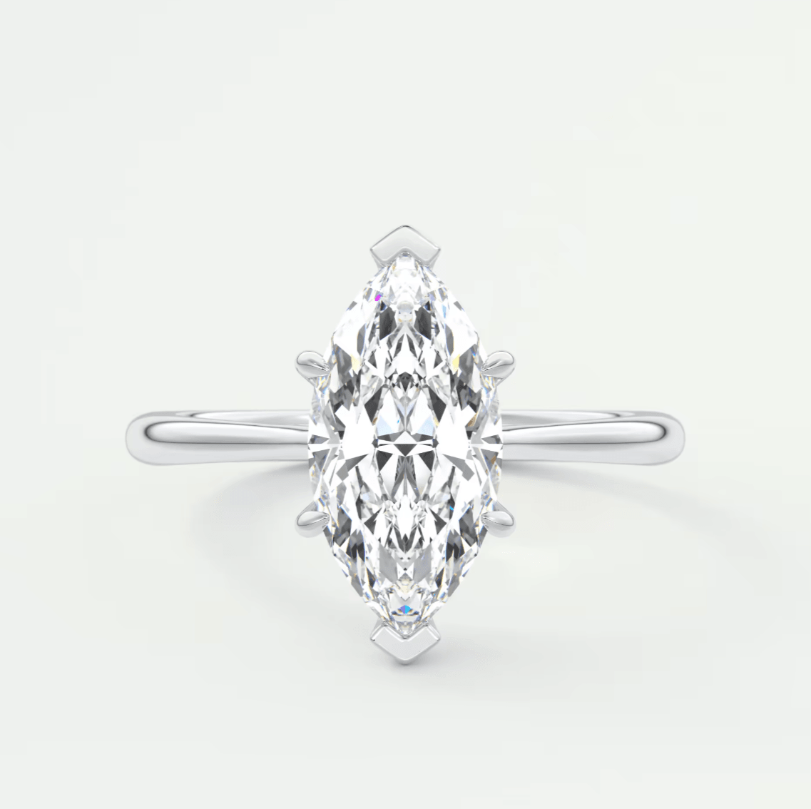 Marquise-cut diamond engagement ring with white gold band, featuring a central stone and two smaller diamonds on either side.