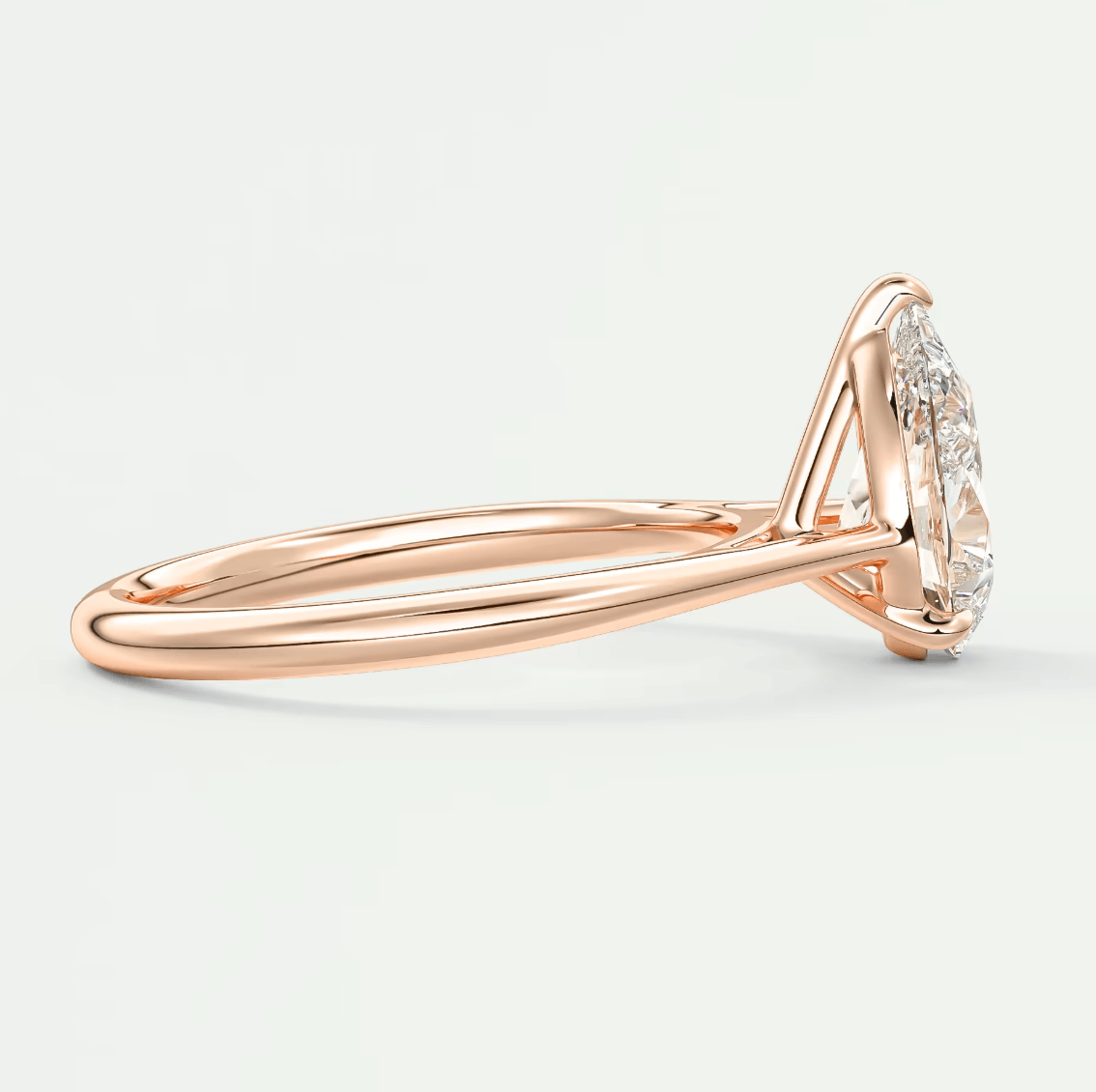 18-karat rose gold engagement ring with a marquise-cut diamond and halo of smaller diamonds.