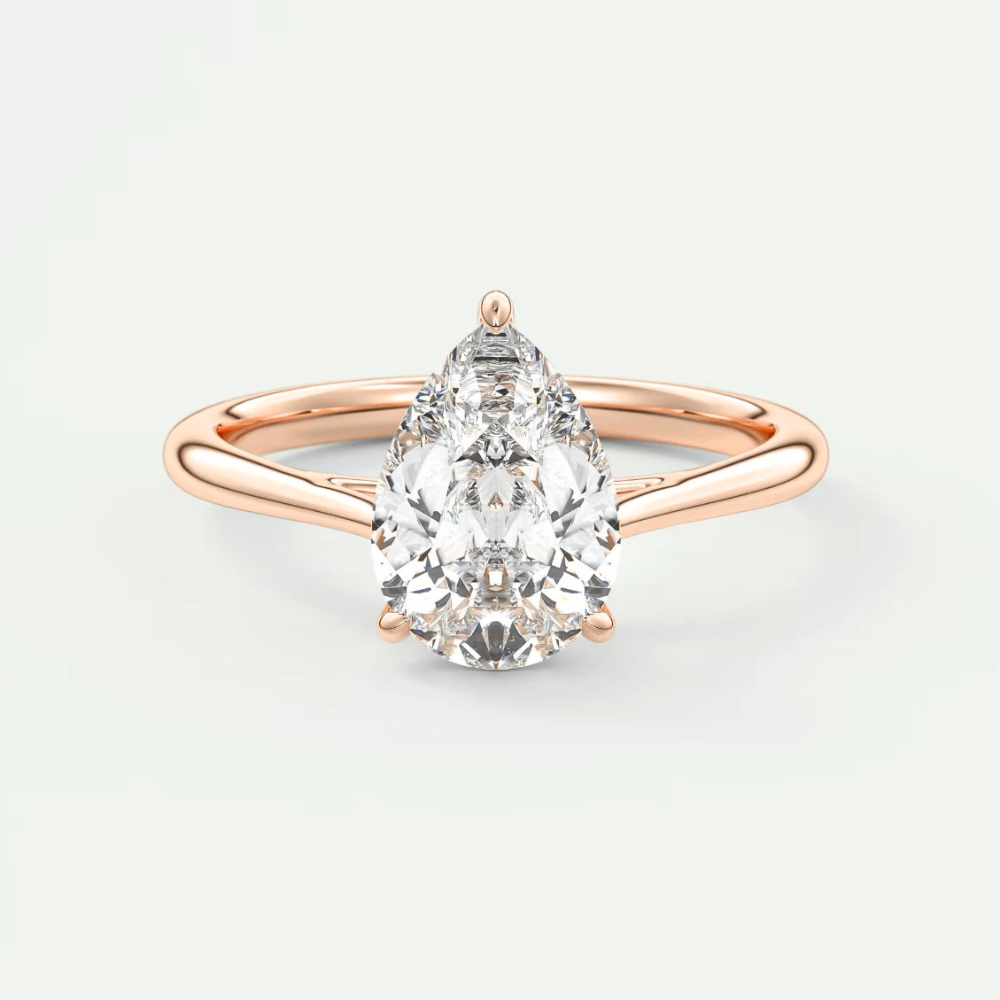 Rose gold pear-shaped diamond engagement ring with a classic solitaire design.