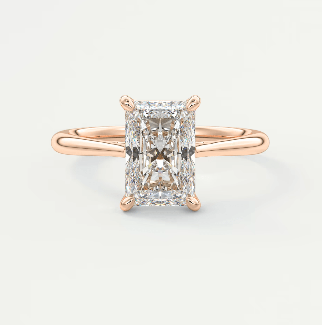 18k rose gold diamond engagement ring with an emerald cut stone.