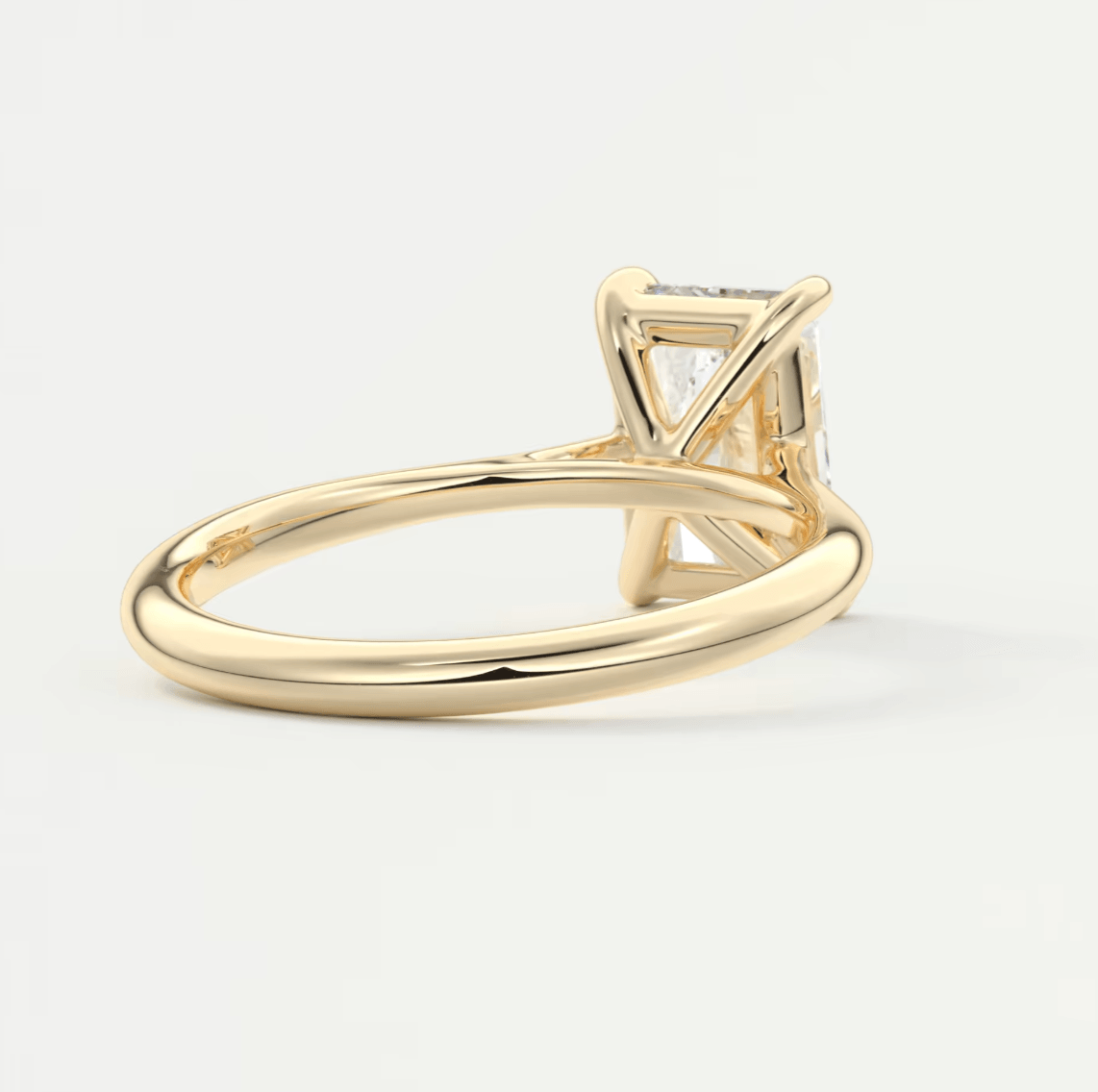 18-karat yellow gold engagement ring with a princess-cut diamond.