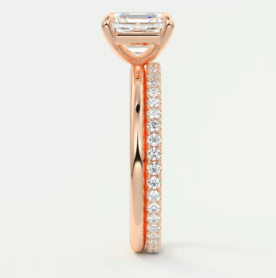 18k rose gold engagement ring with a princess cut diamond and pave set diamonds on the band.