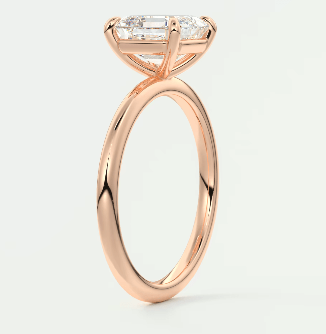 18-karat rose gold engagement ring with an emerald-cut diamond.