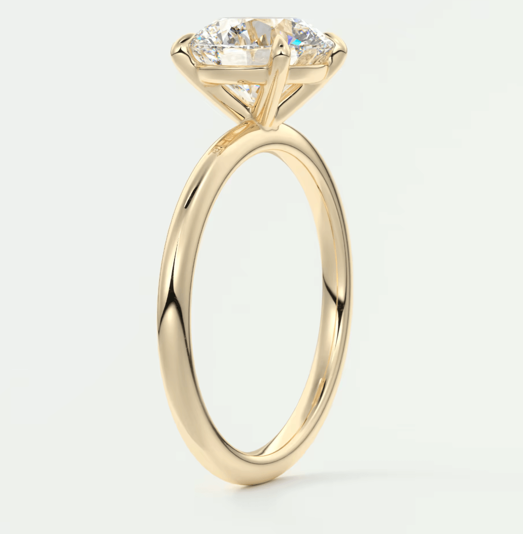 18-karat yellow gold engagement ring with a round diamond center stone and four prongs.