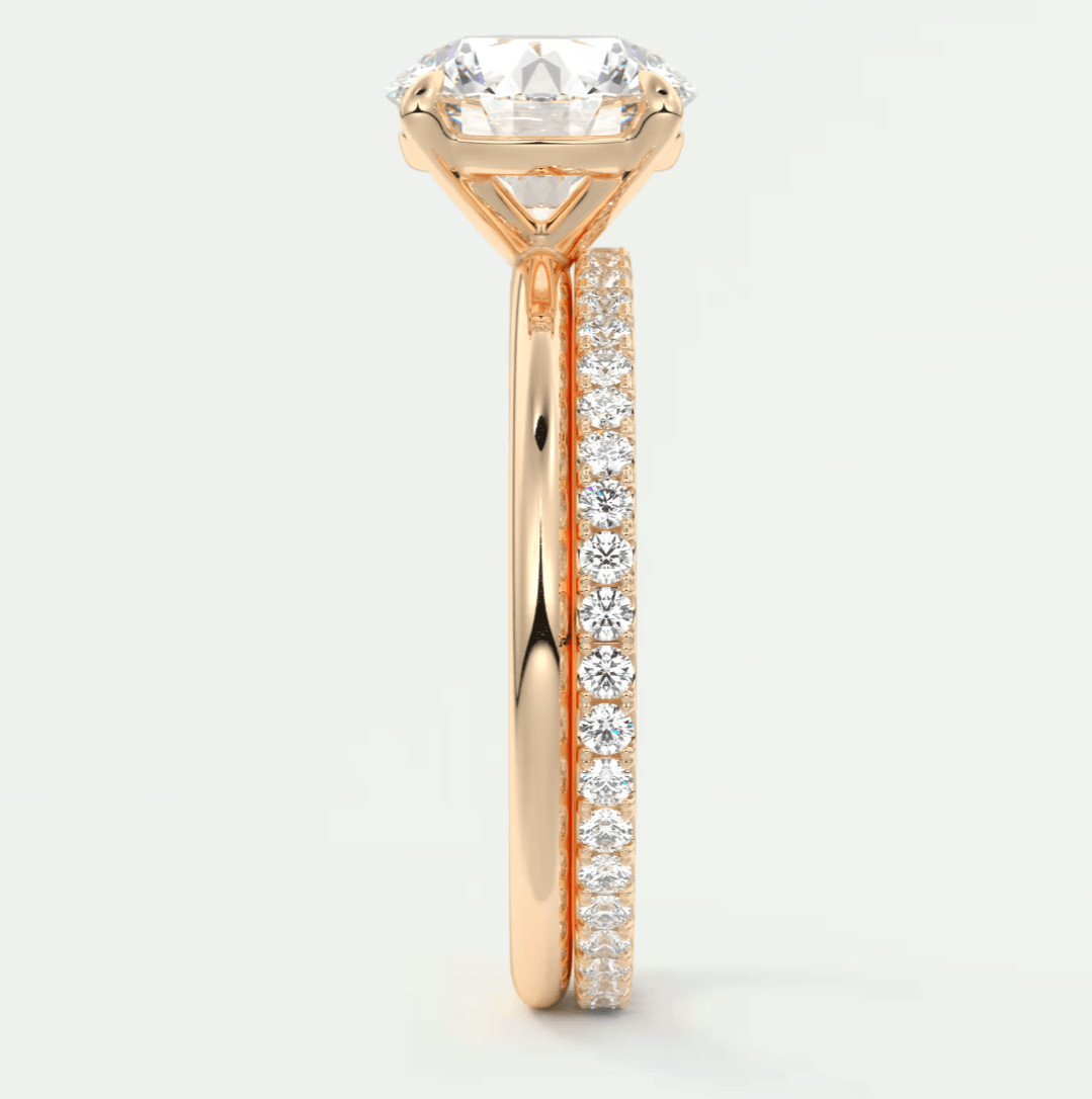 18k rose gold engagement ring with a round diamond center and pavé set diamonds on the band.