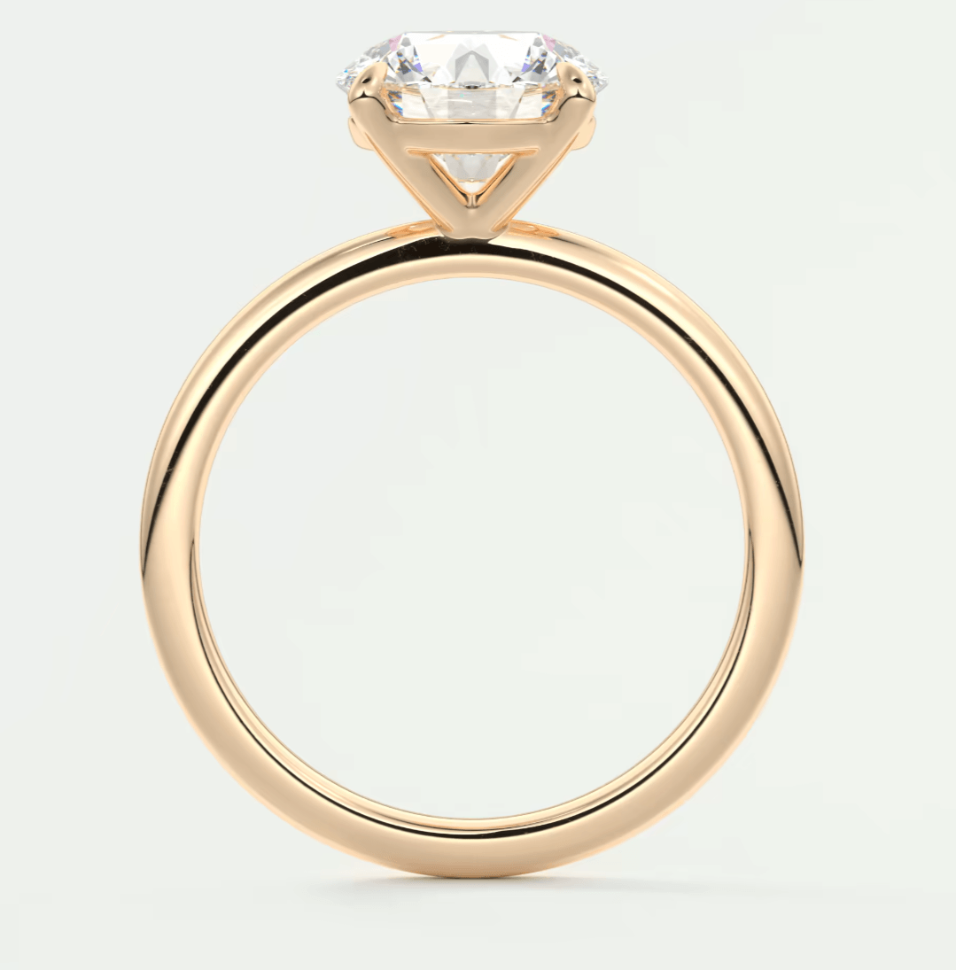 18-karat gold solitaire engagement ring with a round diamond.