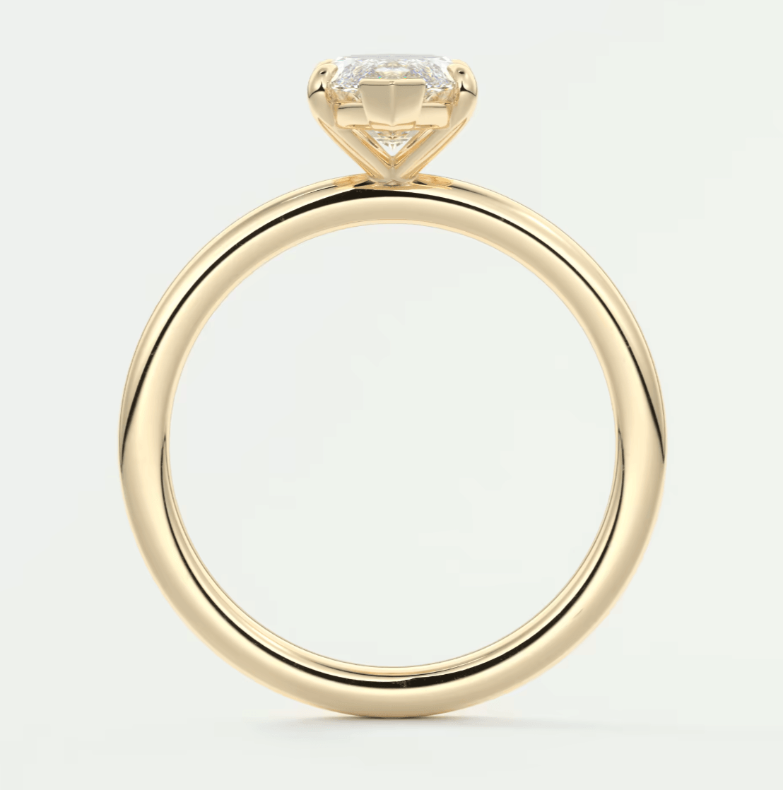 18-karat yellow gold engagement ring with a cushion-cut diamond.