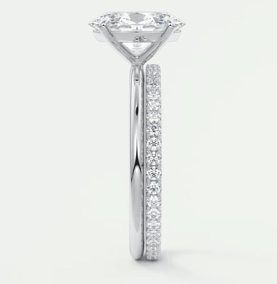 18-karat white gold engagement ring with a round diamond center and pavé set diamonds on the band.