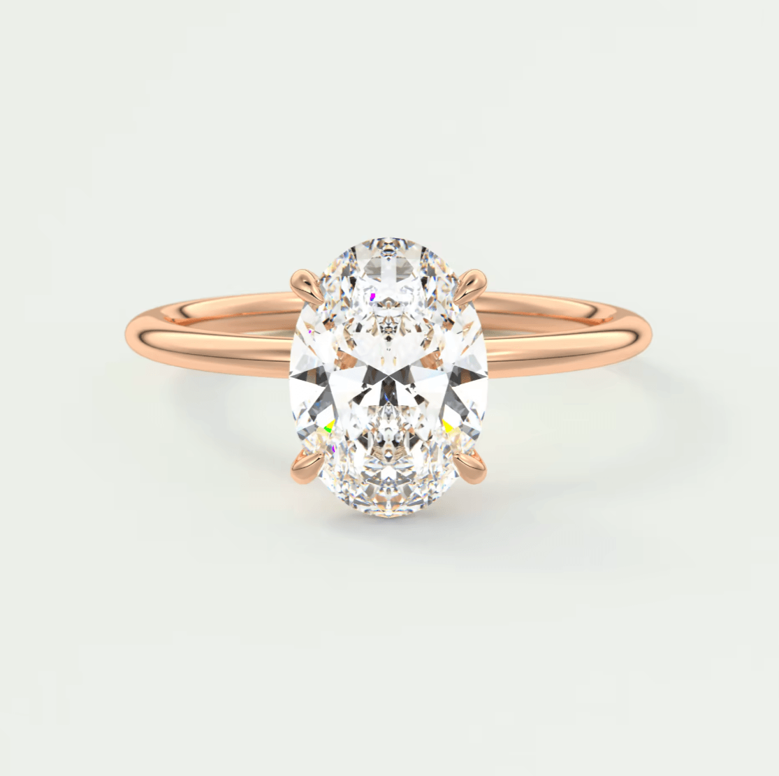 Rose gold oval diamond engagement ring with a solitaire setting.