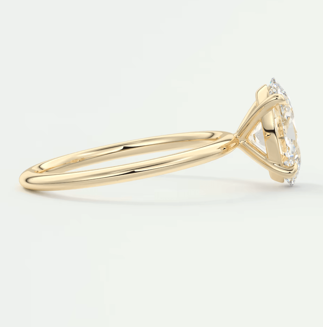 18k yellow gold engagement ring with a marquise-cut diamond and small round diamonds, featuring an elegant halo design.