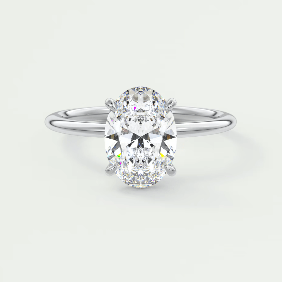 18k white gold oval diamond engagement ring with a princess cut center stone.