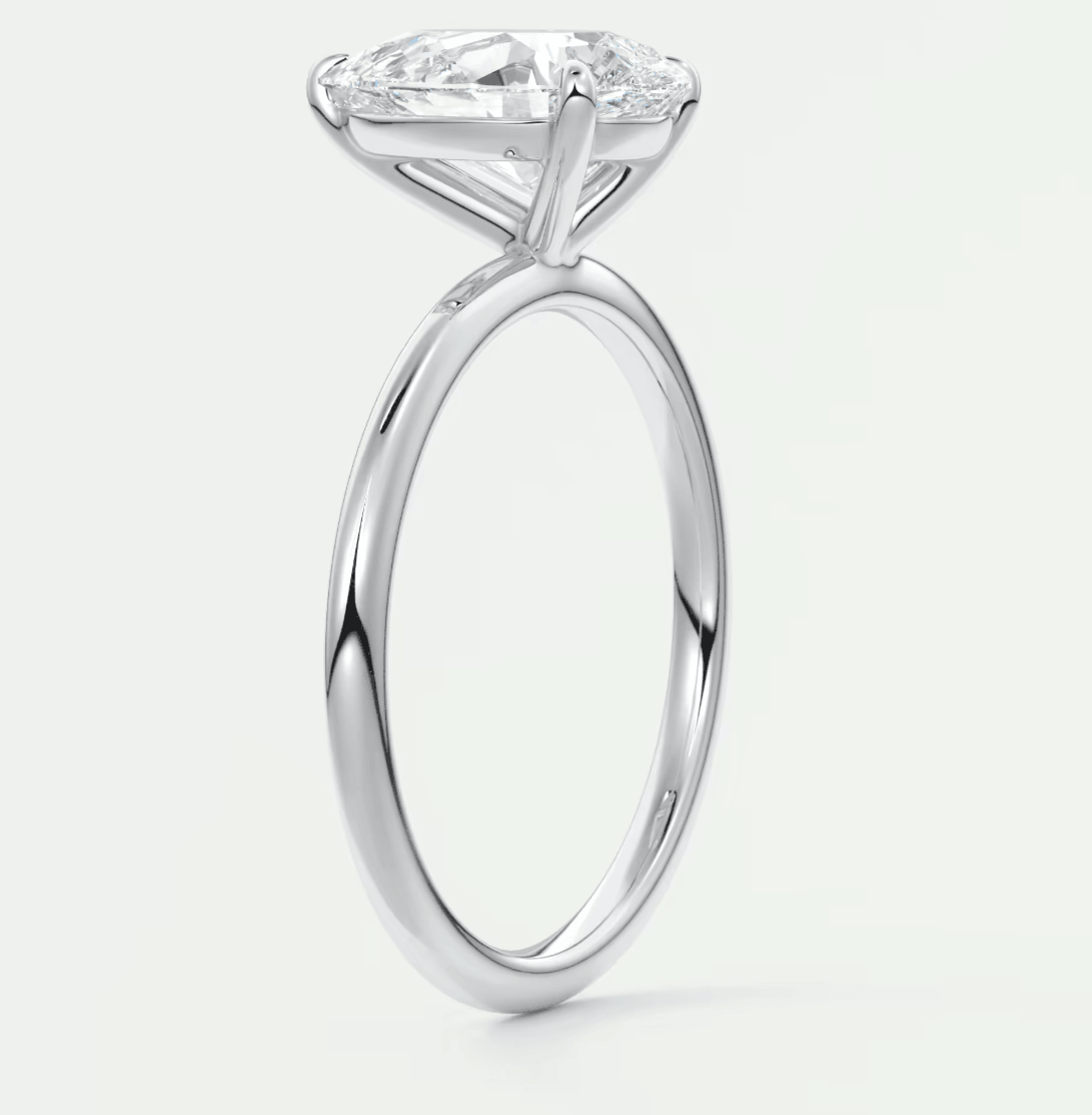 18-karat white gold solitaire engagement ring with a cushion-cut diamond.