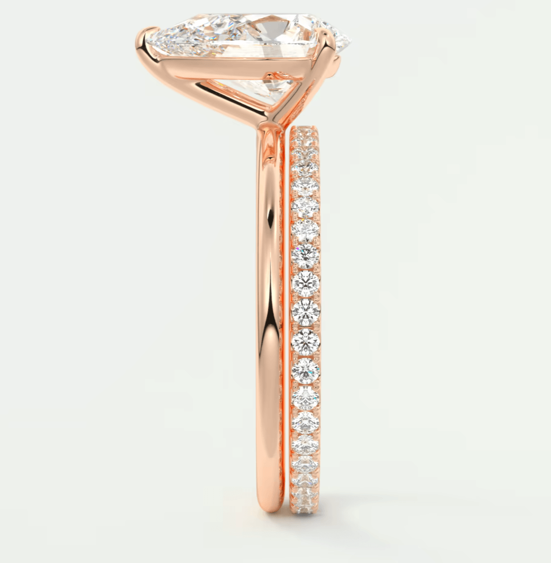 18-karat rose gold engagement ring with a pear-shaped diamond and pavé side stones.
