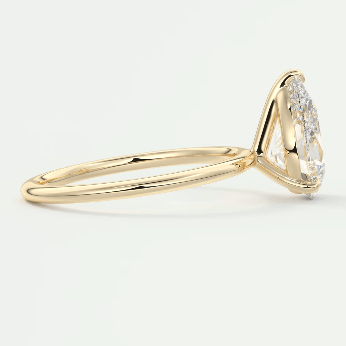 18k yellow gold diamond engagement ring with marquise-cut center stone and smaller diamonds on the band.