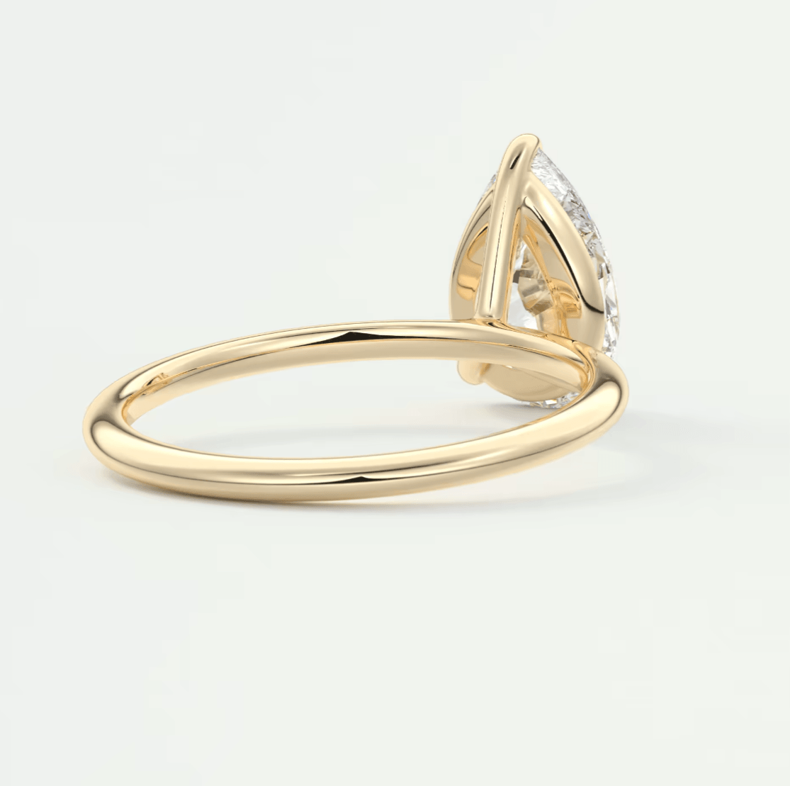 18k yellow gold engagement ring with a pear-shaped diamond.