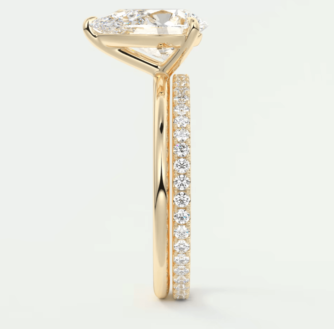 18-karat yellow gold engagement ring with a marquise-cut diamond center stone and pavé set diamonds on the band.