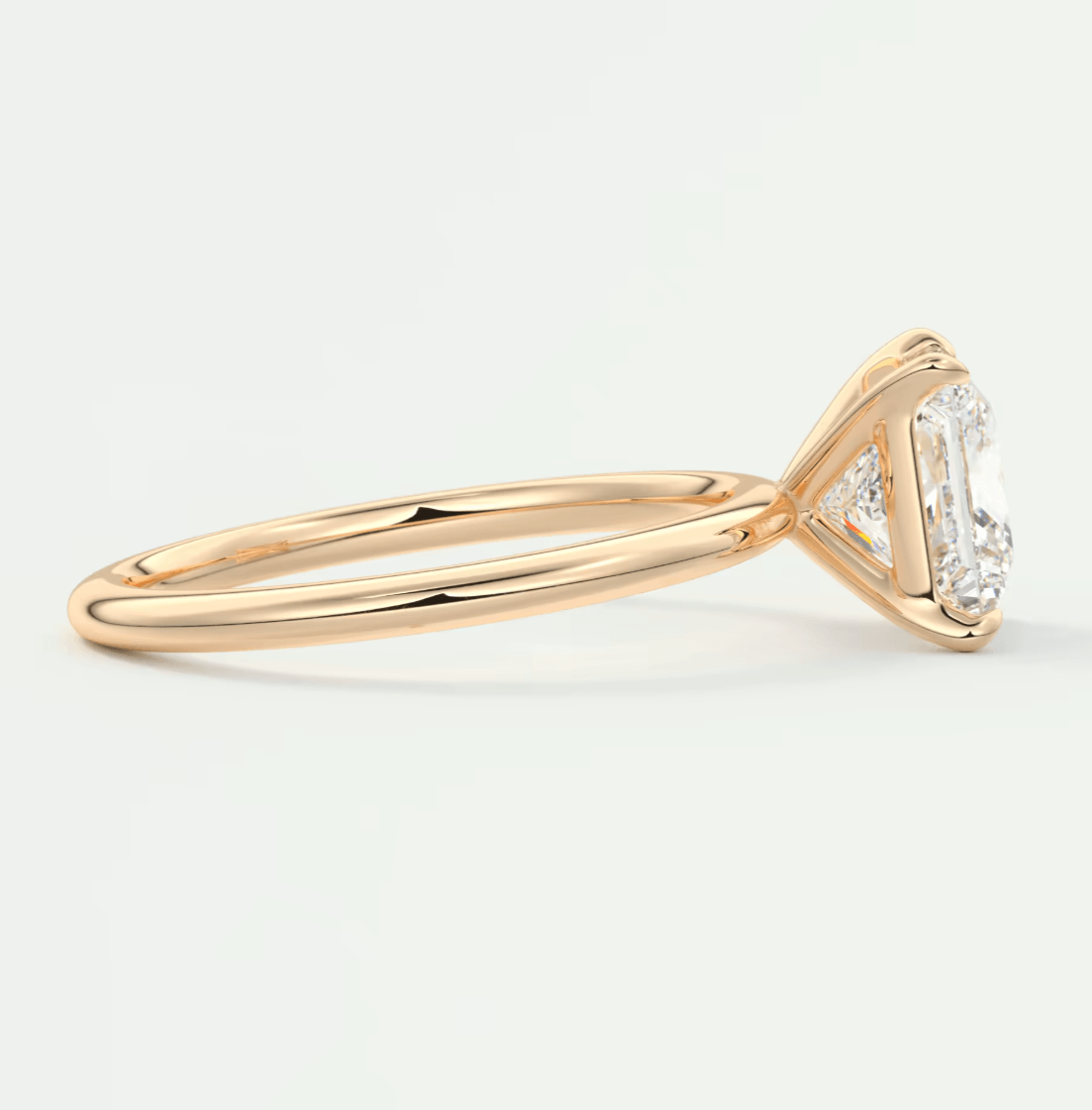 18k yellow gold engagement ring with a princess-cut diamond and two smaller diamonds on the band.