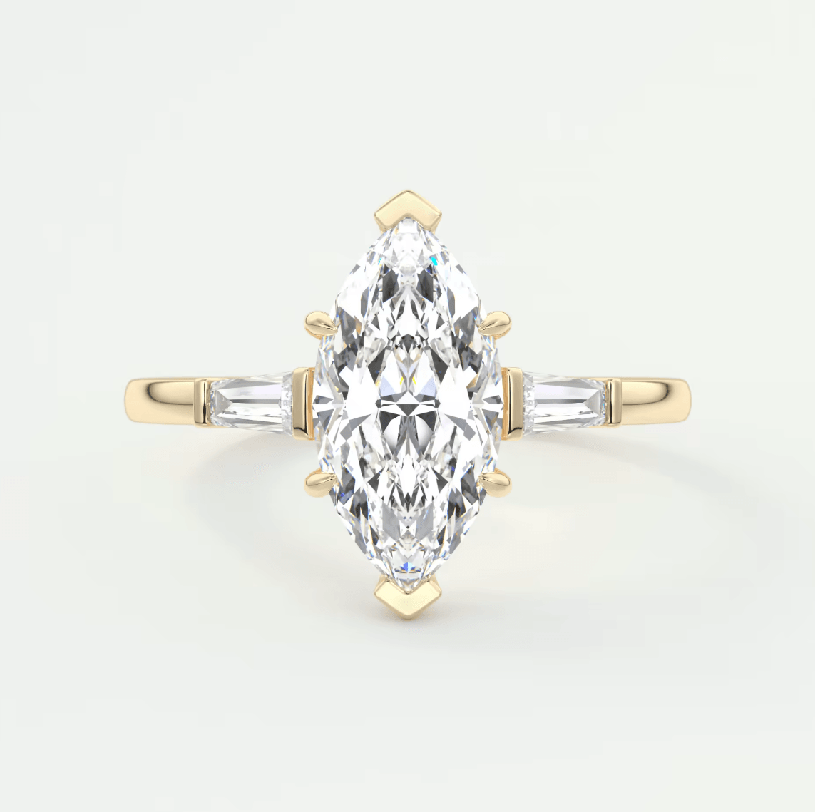 Gold ring with a marquise-shaped diamond on a light gray background