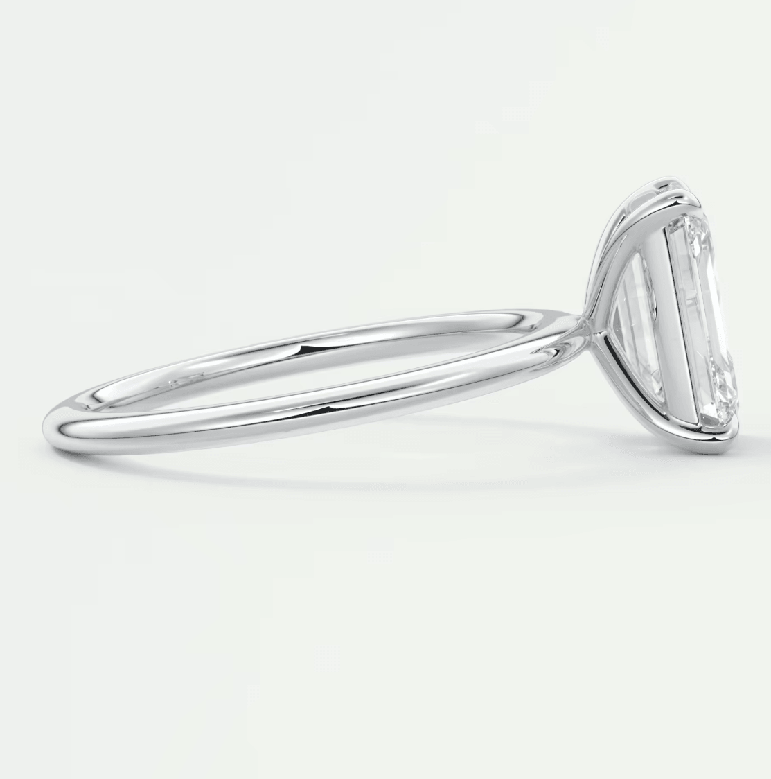 18k white gold solitaire engagement ring with a baguette diamond.