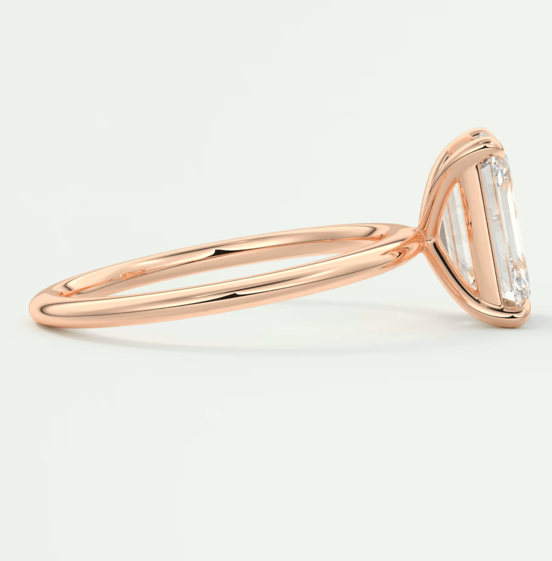 18-karat rose gold engagement ring with a baguette-cut diamond.