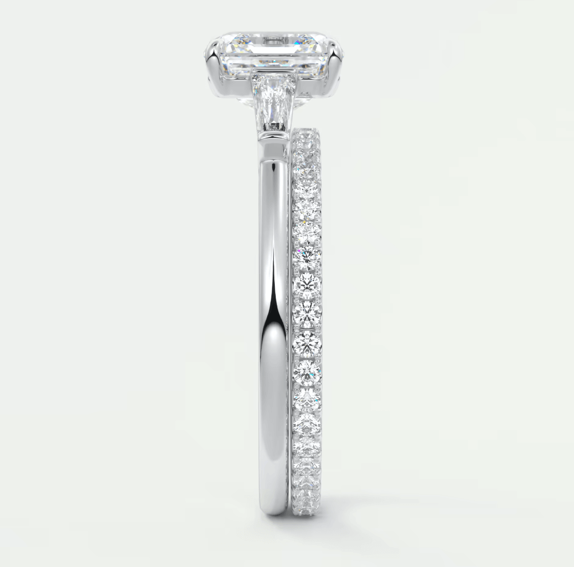 18k white gold engagement ring with an emerald cut diamond and pave set diamonds on the band.