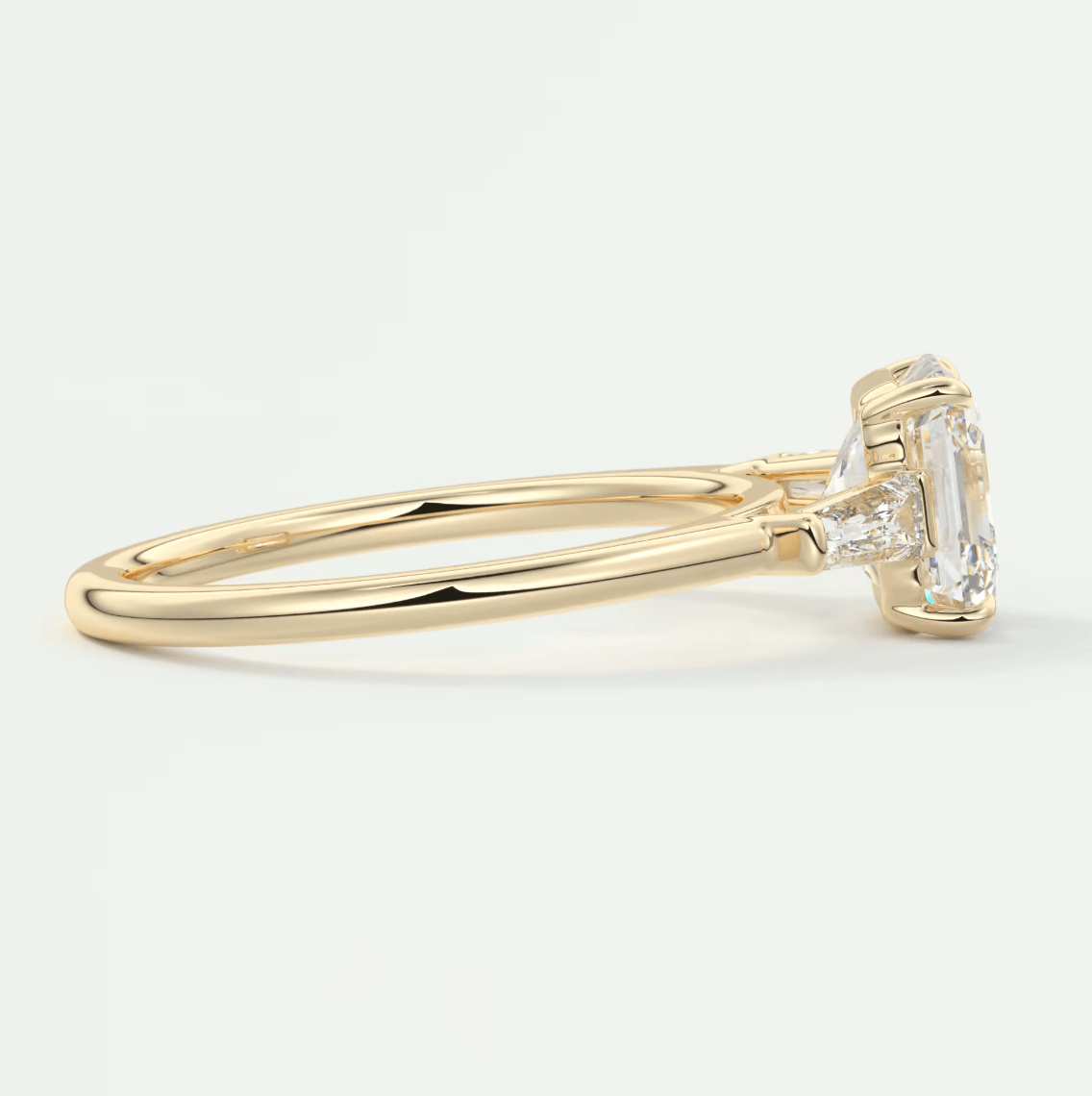 18k yellow gold emerald-cut diamond engagement ring with a halo of smaller diamonds.
