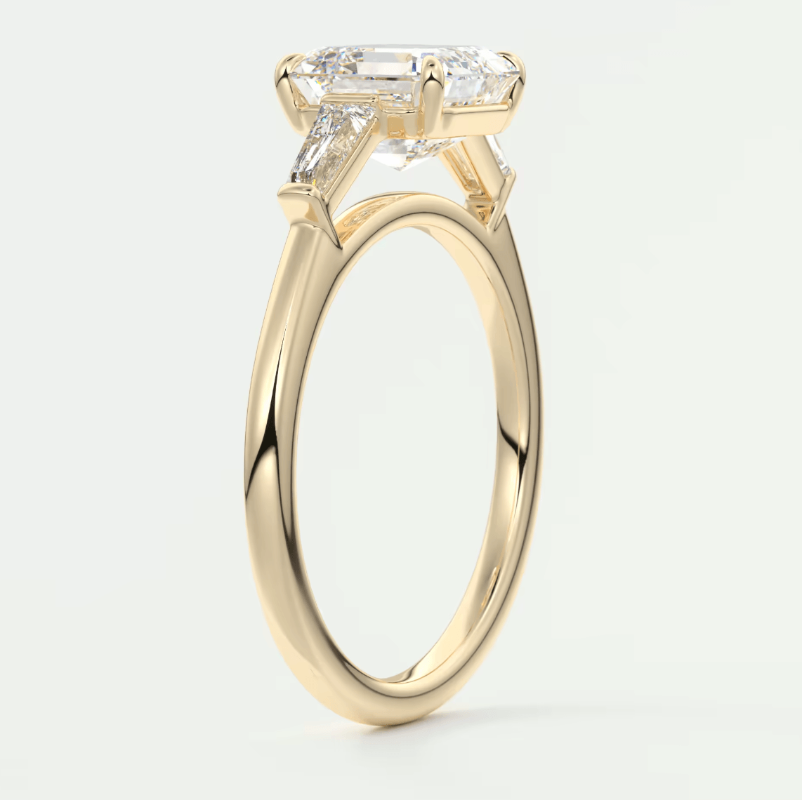 18k yellow gold engagement ring with a princess cut diamond and two side baguette diamonds.