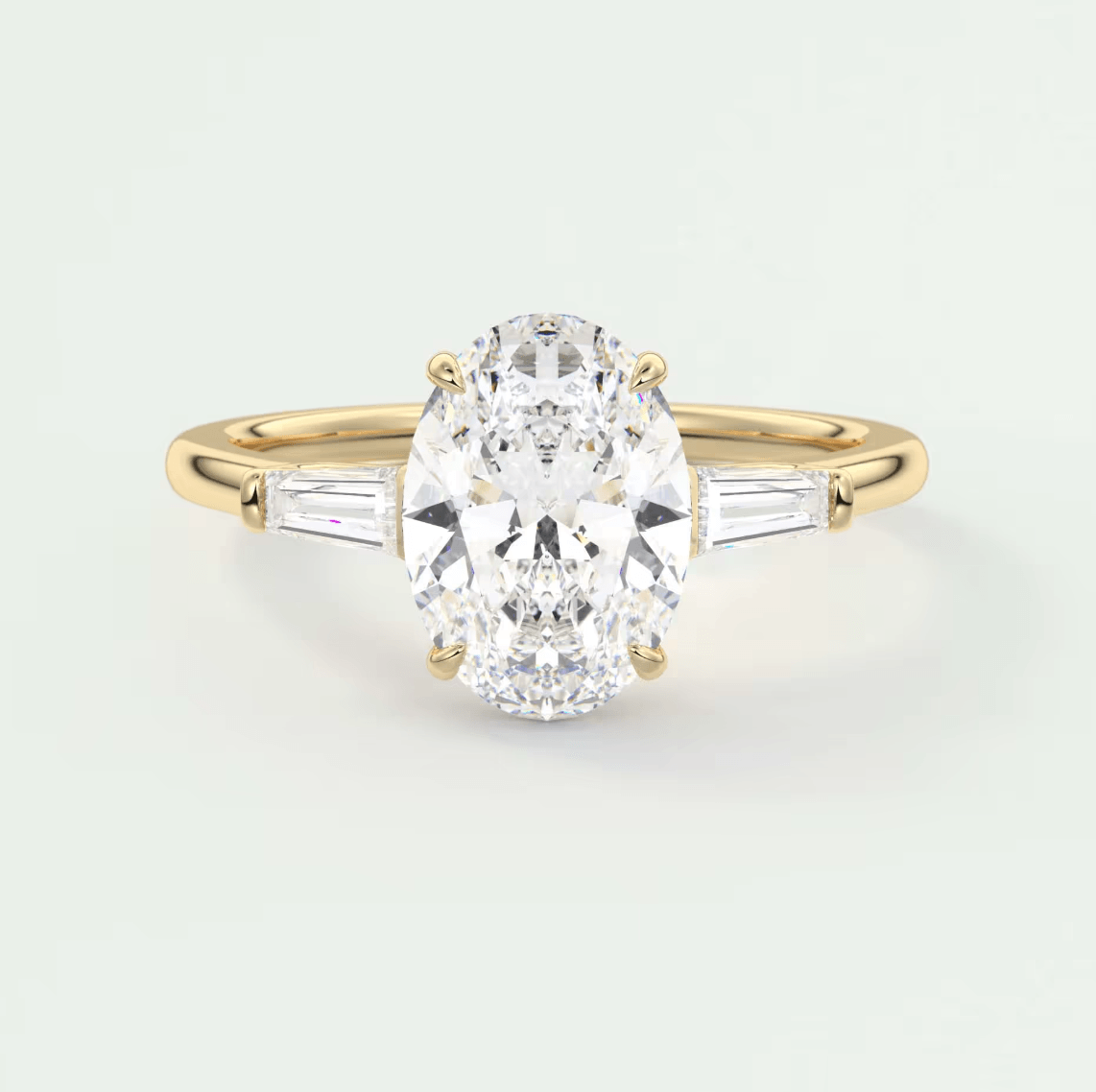 18k yellow gold diamond engagement ring with an oval-cut center stone and baguette side stones.