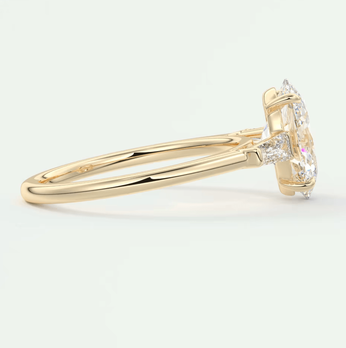 18k yellow gold engagement ring with a marquise-cut diamond and two smaller round diamonds.