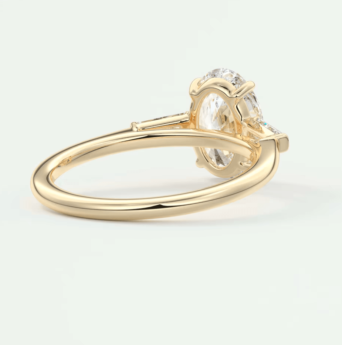 18k yellow gold engagement ring with a cushion-cut diamond and two smaller diamonds on either side.